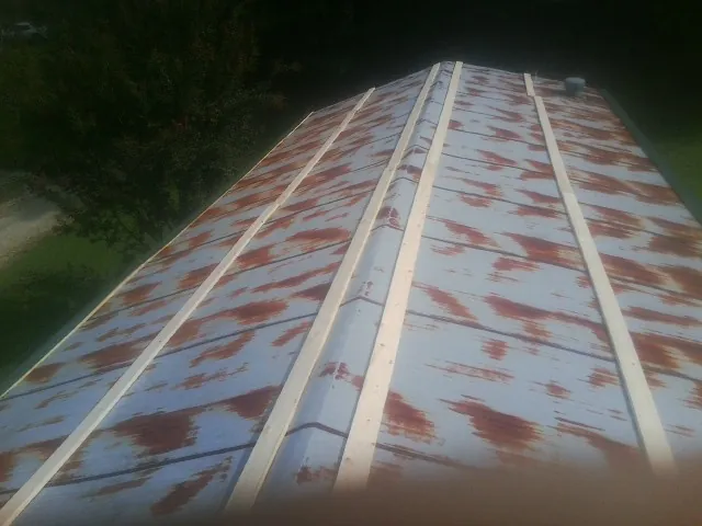 Rusted metal roof panels with new wood purlins before replacement — Storm Damage Roof Repair in Fulshear by Roofing Brothers