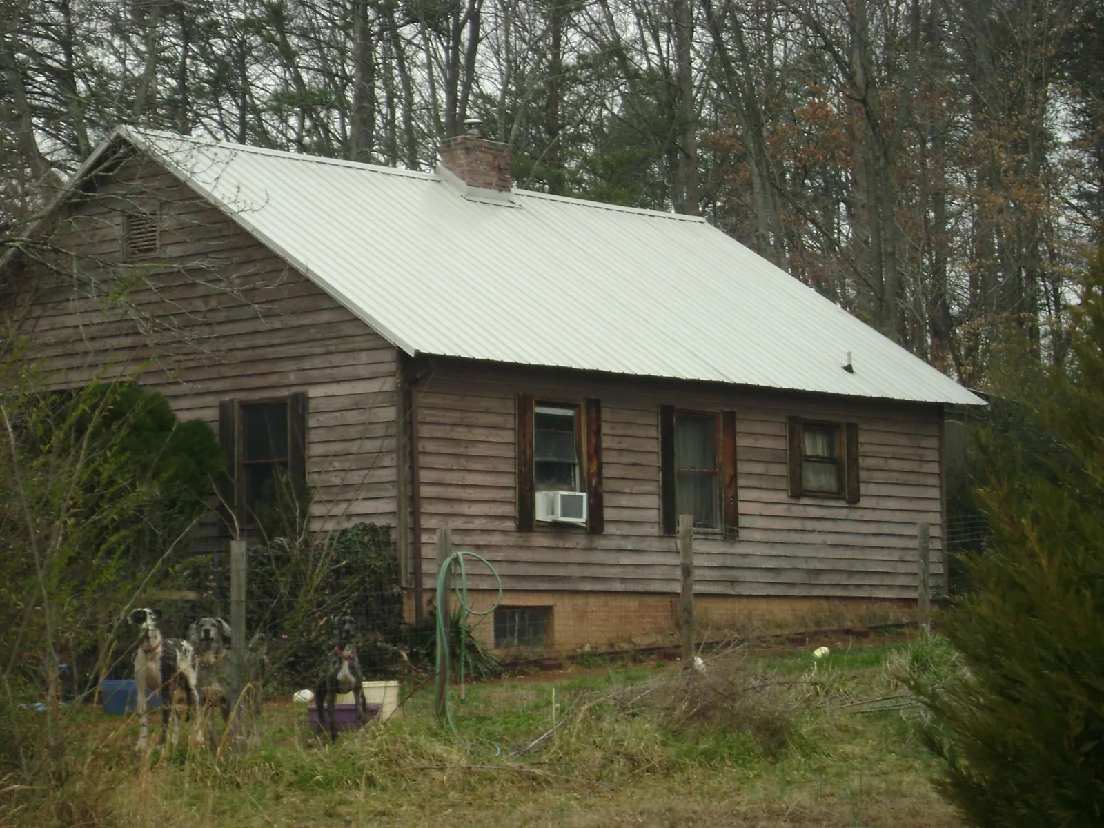 White metal roof on an old wood sided farmhouse, from a Metal Roof Installation job in Fulshear